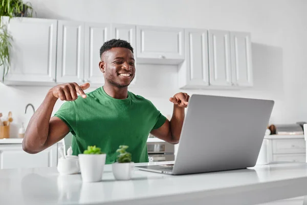Feliz sordo afroamericano freelancer utilizando lenguaje de señas durante la reunión en línea en el ordenador portátil - foto de stock
