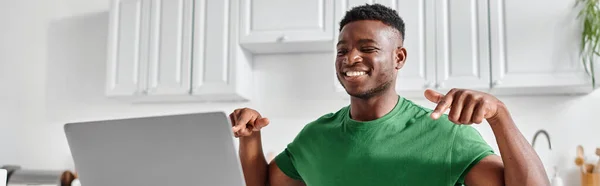 Щасливий глухий афроамериканський фрілансер, використовуючи мову жестів під час онлайн-зустрічі на ноутбуці, банер — стокове фото