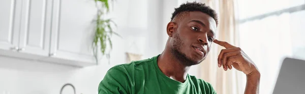Schöner und junger afrikanisch-amerikanischer Mann beobachtet Online-Webinar von Laptop zu Hause, Banner — Stockfoto