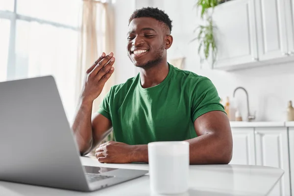 Happy deaf african american freelancer using sign language for communication during online meeting — Stock Photo
