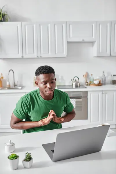Глухонемой африканский фрилансер, использующий язык жестов для общения во время видеозвонка на ноутбуке — стоковое фото