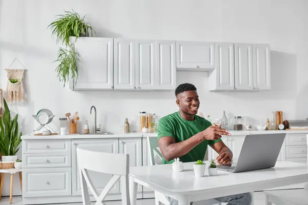 Cheerful deaf african american freelancer using sign language for communication during video call — Stock Photo