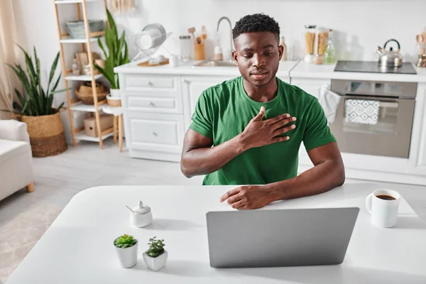 Homme afro-américain en t-shirt vert utilisant le langage des signes pour la communication en ligne, geste de la main — Photo de stock