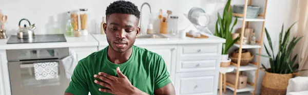 Hombre afroamericano en camiseta verde usando lenguaje de señas para la comunicación en línea, bandera - foto de stock