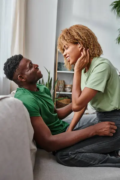 Retrato de mulher afro-americana surda alegre no aparelho auditivo sorrindo perto do namorado em casa — Fotografia de Stock