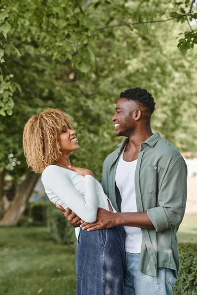 Afrikanisches amerikanisches Paar lacht und umarmt sich im Freien, schwarze Frau in Hosenträgern und Mann — Stockfoto