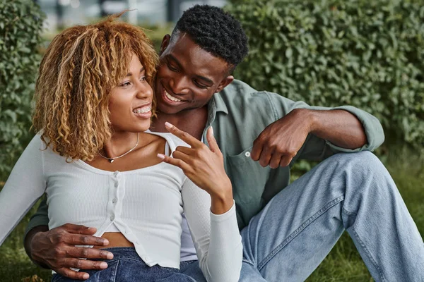 Femme afro-américaine gaie dans les bretelles en utilisant le langage des signes pour la communication avec le petit ami — Photo de stock