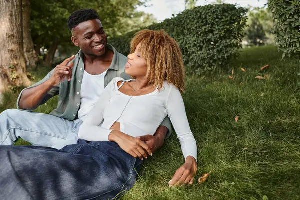 Cheerful african american man using sign language to communicate with girlfriend in park — Stock Photo