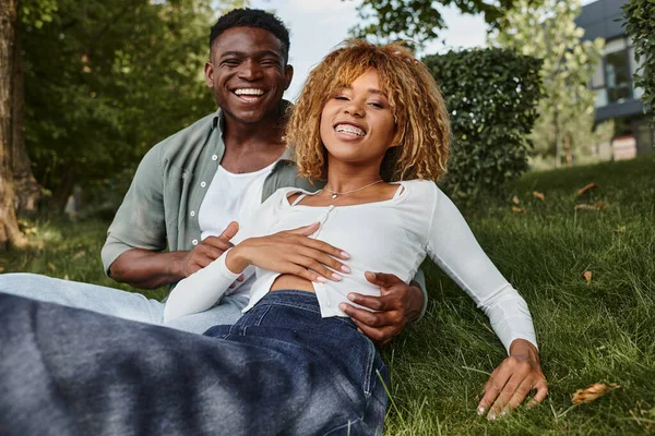 Cheerful african american couple having quality time with each other while sitting in park — Stock Photo