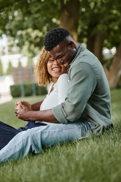 Positive afrikanisch-amerikanische Paar verbringt Zeit miteinander im Park, Händchen haltend — Stockfoto