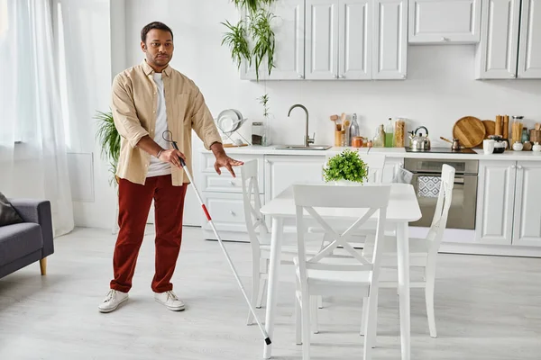Good looking blind indian man in cozy casual outfit using his walking stick while in his kitchen — Stock Photo