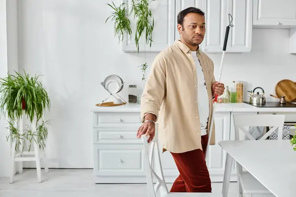 Good looking indian man with visual impairment using walking stick while at home, disabled — Stock Photo