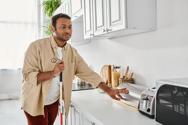 Bonito deficiente índio homem no homewear segurando andando vara enquanto prepara comida, cego — Fotografia de Stock