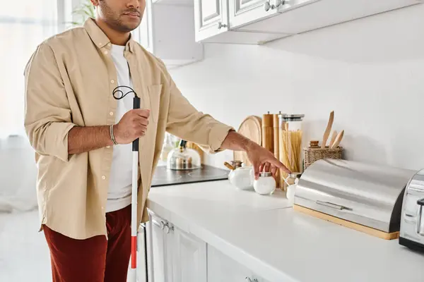 Cropped view of disabled indian man in homewear holding walking stick while preparing food, blind — Stock Photo