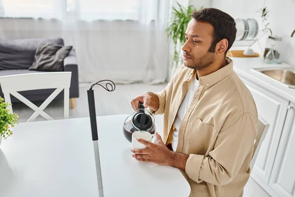 Indian blind attractive man in casual attire with walking stick sitting and pouring himself coffee — Stock Photo