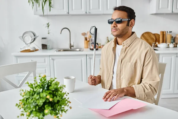Good looking indian blind man in cozy attire with glasses and walking stick reading braille code — Stock Photo