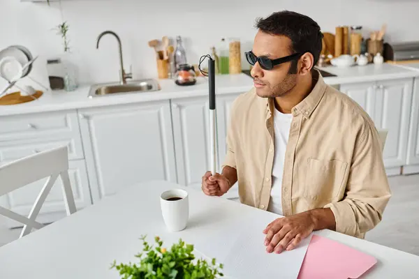 Handsome indian blind man in cozy attire with glasses and walking stick reading braille code — Stock Photo