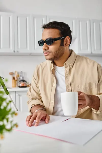 Homem indiano atraente com deficiência visual em óculos lendo código braille enquanto na cozinha — Fotografia de Stock