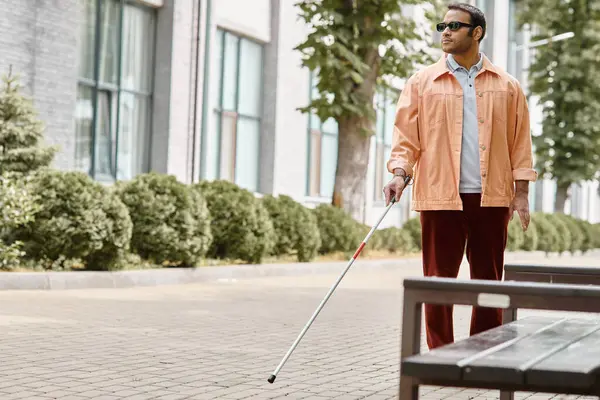 Bonito índio deficiente homem com óculos e bengala em vívida jaqueta laranja andando no parque — Fotografia de Stock