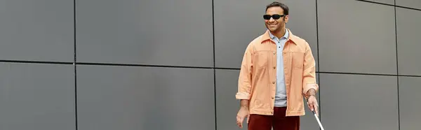 Lustiger indischer Blinder in Jacke mit Spazierstock und Brille mit grauer Wand auf Hintergrund, Banner — Stockfoto