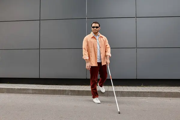 Attraktiver indischer Mann mit Blindheit in Jacke mit Brille und Stock mit grauer Wand auf Hintergrund — Stockfoto