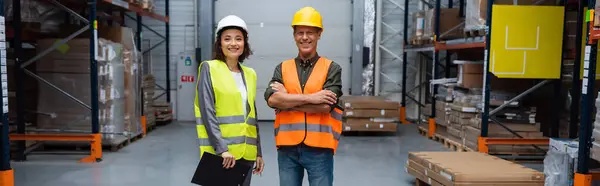 Happy warehouse supervisor and employee in hard hats looking at camera, horizontal banner — Stock Photo