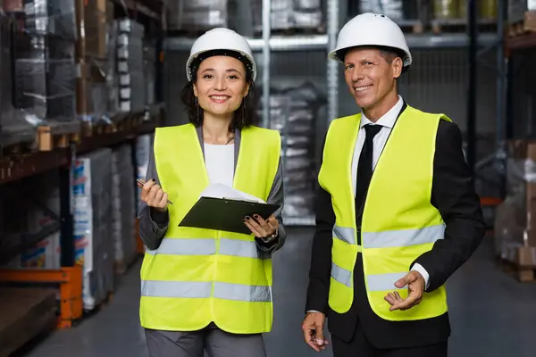 Professional headshot, middle aged supervisor and female employee in hard hat with clipboard — Stock Photo