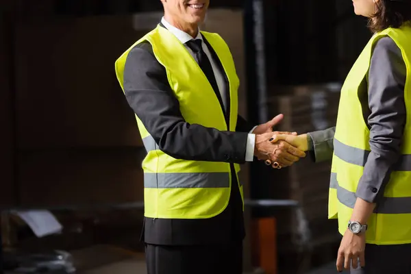 Cropped shot of happy supervisor and his colleague holding paper cups with coffee and shaking hands — Stock Photo