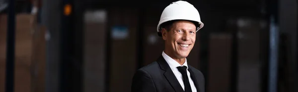 Feliz hombre de negocios de mediana edad en sombrero duro y traje de almacén sonriente, bandera profesional - foto de stock