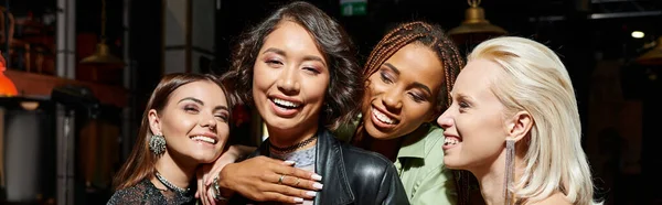 Excited and vibrant multicultural female friends embracing in bar during party, horizontal banner — Stock Photo