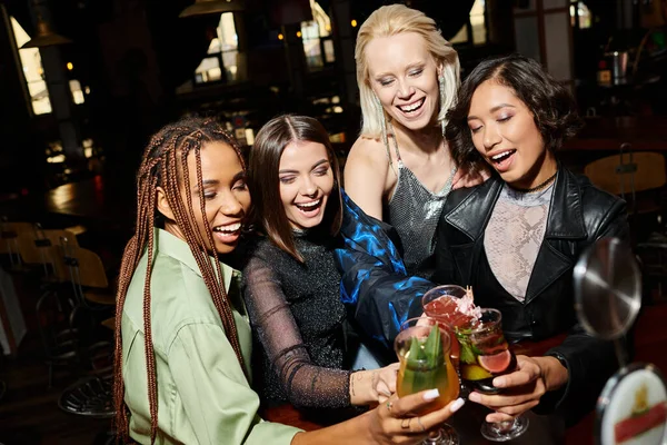 Animado e jovens multiculturais mulheres clinking deliciosos coquetéis no bar, tempo de festa feliz — Fotografia de Stock