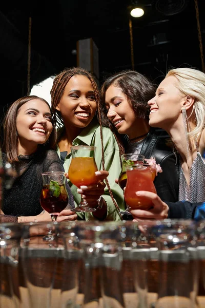 Classy and cheerful female friends holding glasses with delicious cocktails in bar, leisure — Stock Photo