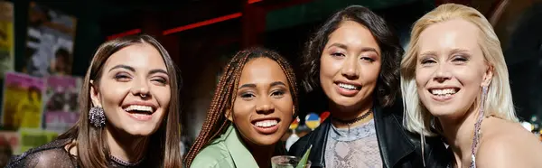Молодые соблазнительные многорасовые девушки улыбаются перед камерой во время вечеринки в современном баре, баннер — стоковое фото