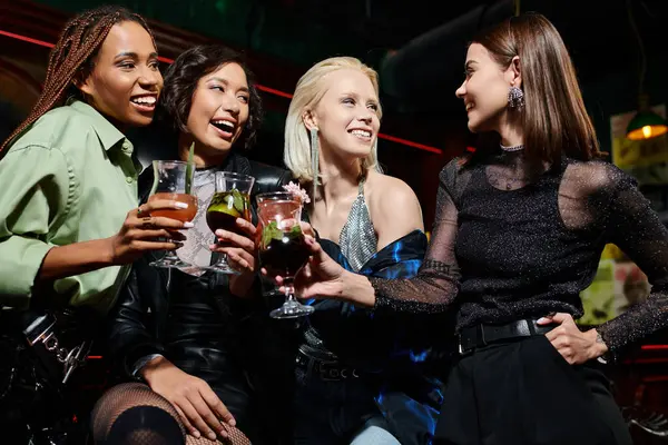 Moda multietnica sorridente con deliziosi cocktail parlare al bar, stile di vita moderno — Foto stock