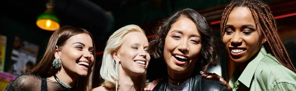 Різноманітна група модних мультикультурних друзів, які посміхаються в нічному барі, горизонтальний банер — стокове фото