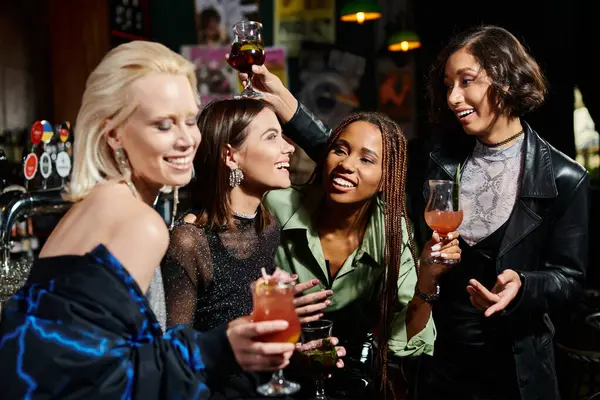 Glückliche asiatische Frau prostet mit Cocktail in der Nähe glamouröser multiethnischer Freunde in der Bar zu — Stockfoto