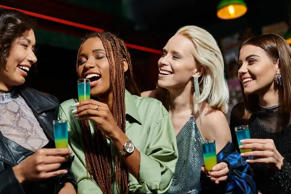 Excited african american woman with closed eyes and shot glasses near multiethnic girlfriends — Stock Photo