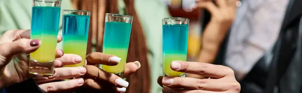 Cropped view of blurred multiethnic girlfriends holding shot glasses in modern bar, banner — Stock Photo