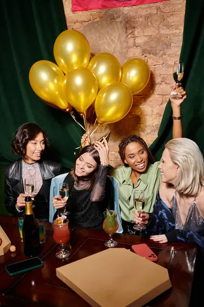 Donna afroamericana brindare con champagne vicino a fidanzate multirazziali nel bar, festa di compleanno — Foto stock