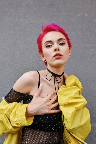 Заманчивая модная женщина с розовыми волосами позирует на камеру в городской одежде, концепция моды — стоковое фото