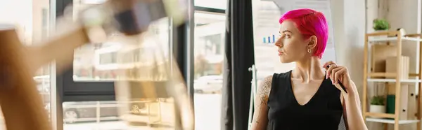 Красива молода бізнес-леді в повсякденному одязі з татуюваннями тримає ручку і дивиться геть, банер — стокове фото