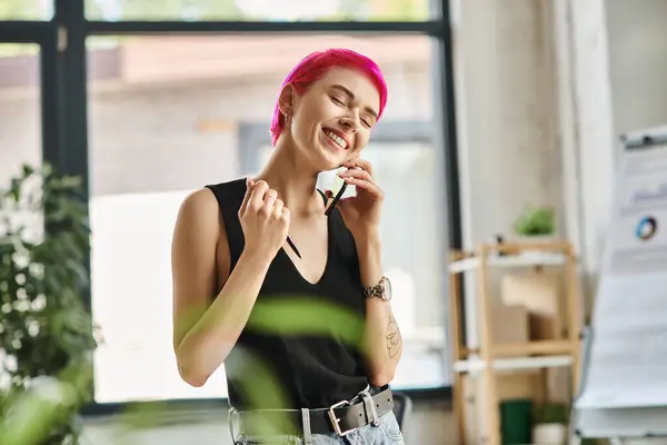 Joyeuse jeune femme d'affaires avec des tatouages parlant par téléphone et souriant joyeusement avec les yeux fermés — Photo de stock