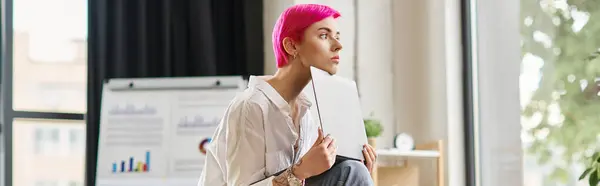 Nachdenkliche junge Geschäftsfrau in weißem Hemd sitzt und hält ihren Laptop im Büro, Transparent — Stockfoto
