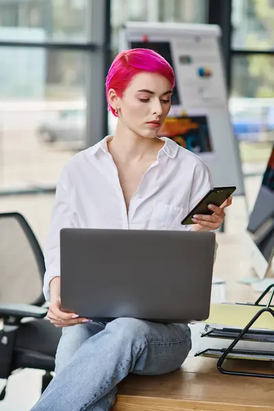 Attraktive junge Professionelle sitzt und schaut auf ihr Handy mit Laptop auf dem Schoß, Geschäft — Stockfoto