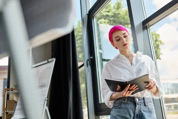 Attraktive kurzhaarige Frau im weißen Hemd, die im Büro ihre Notizen betrachtet, Geschäftskonzept — Stockfoto