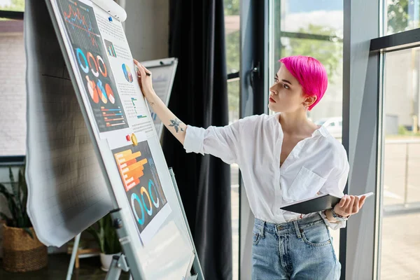 Attraente giovane lavoratrice in camicia bianca e jeans guardando grafici al suo ufficio, affari — Foto stock