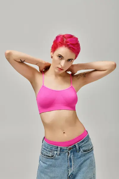 Attrayant jeune femme avec les cheveux roses et tatouages posant et regardant la caméra, concept de mode — Photo de stock