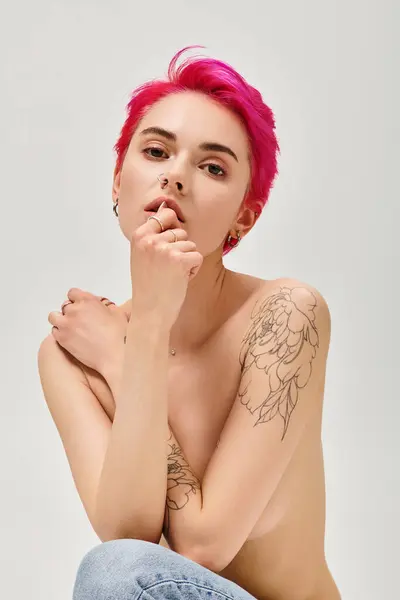 Gracia femenina, hermosa mujer en topless con el pelo rosa mirando a la cámara sobre fondo gris - foto de stock
