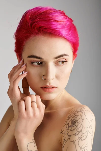 Retrato de mujer joven hermosa y en topless con hombros desnudos y tatuaje sobre fondo gris — Stock Photo