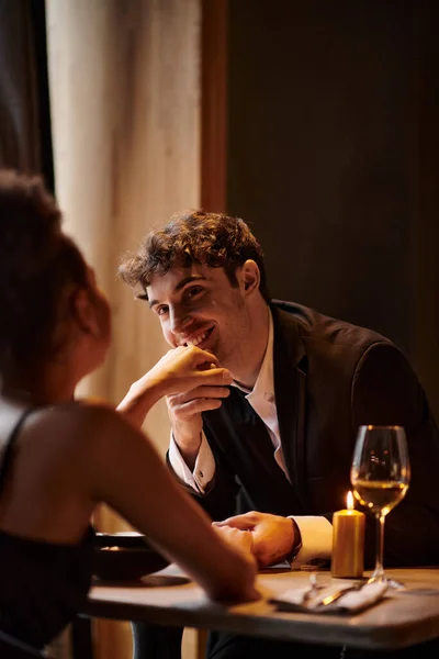Joyful gentleman in elegant attire kissing hand of girlfriend during date on Valentines day — Stock Photo